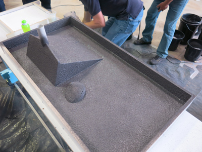 GFRC mist coat applied to mold for concrete countertop with integral ramp sink