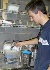 man in concrete countertop shop weighing blue pigment on small scale