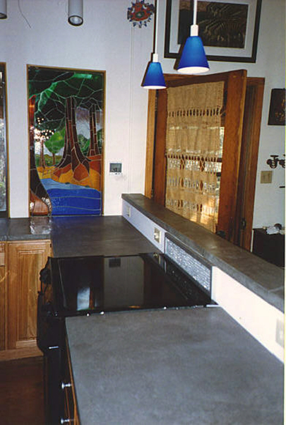 gray concrete countertop in kitchen with stained glass and wood