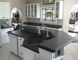 multi level angular black concrete countertops with rock edge on kitchen island