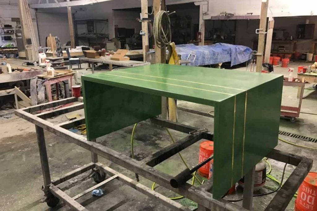green concrete coffee table with embedded brass strips in shop
