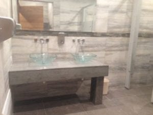 thick concrete vanity with glass vessel sinks