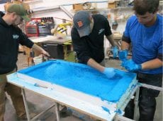 placing bright blue concrete in mold