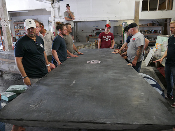 inspecting large concrete table top on casting table