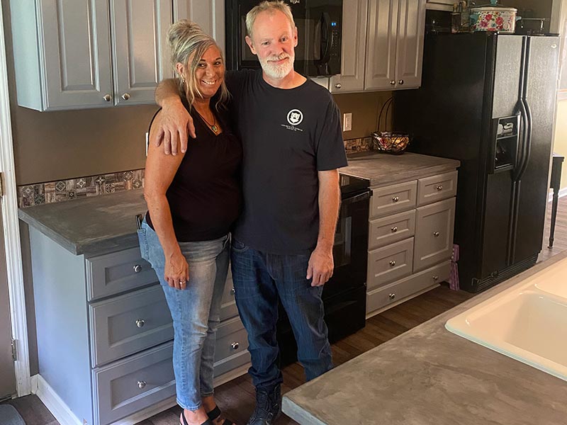 DIY concrete countertops husband and wife smiling in kitchen