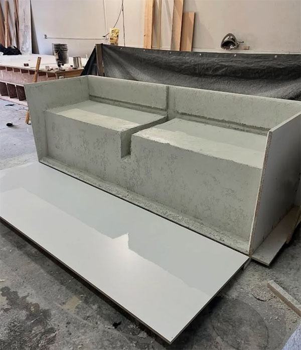 Concrete placed in a melamine mold for a precast sofa section