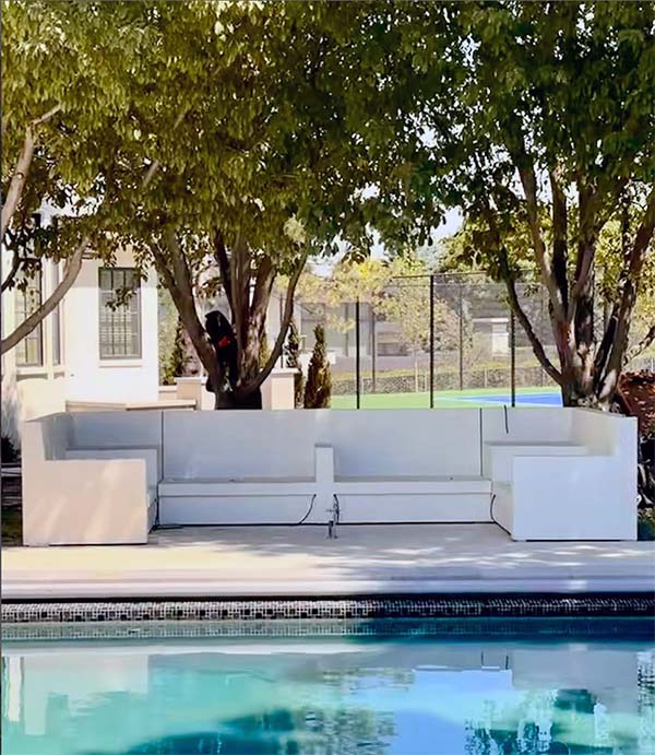 White precast concrete sectional sofa installed beside a swimming pool