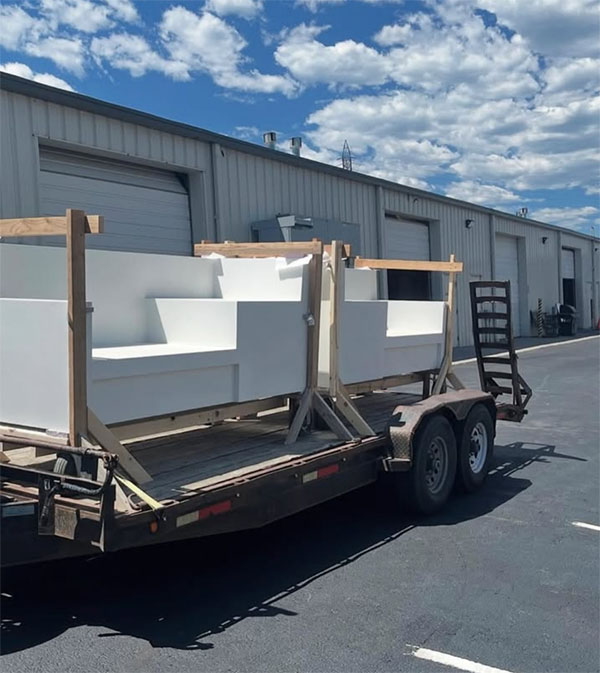 Precast concrete sofa sections braced upright on a flatbed trailer for delivery